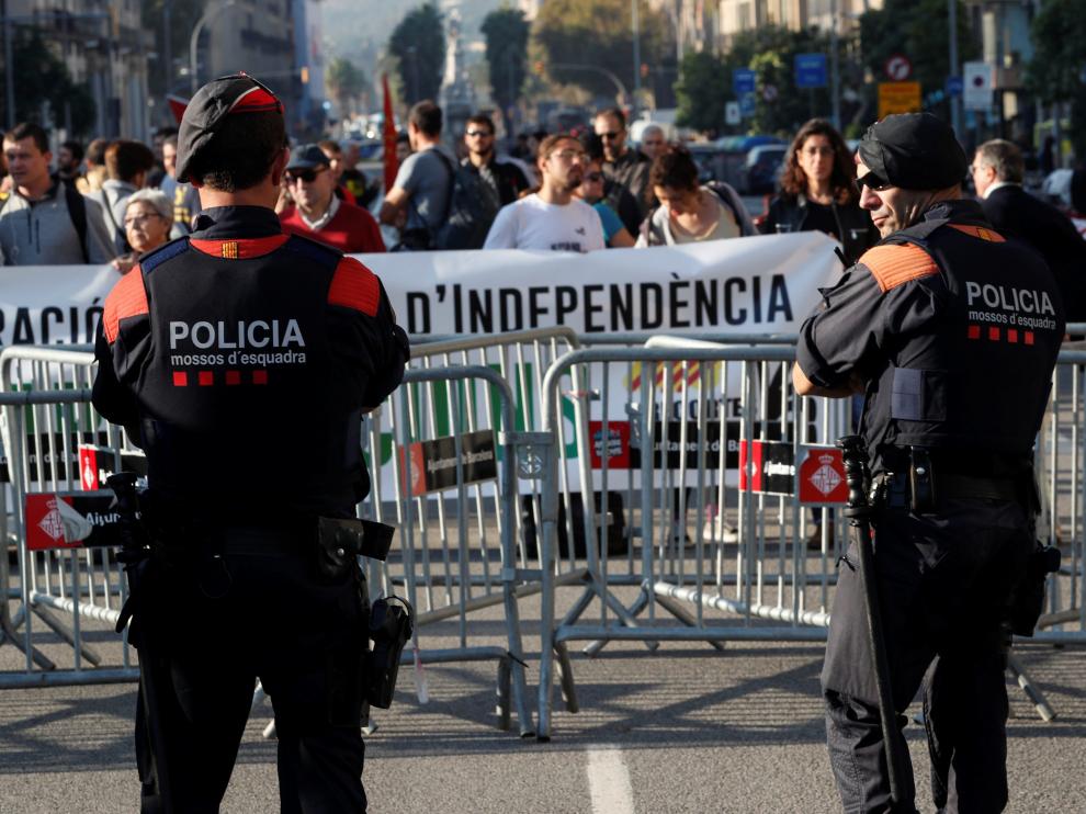 Dos mossos vigilan la concentración de personas que van llegando ante el Parlament este viernes.