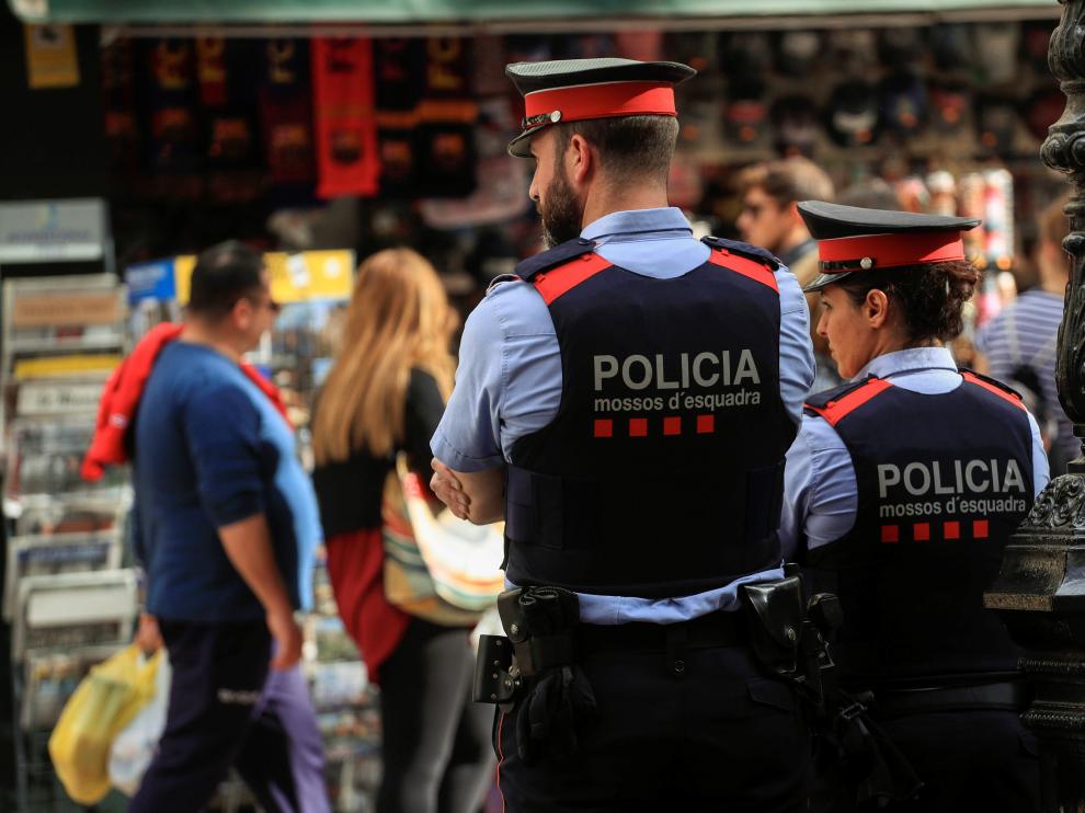 Dos mossos velan por la seguridad en una calle de Barcelona, este sábado.