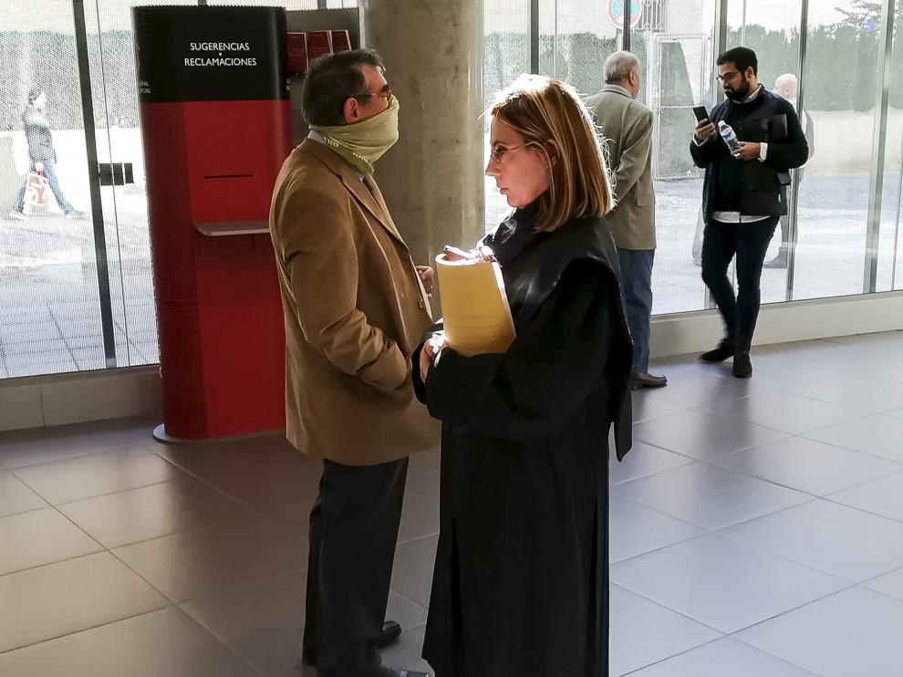 El acusado se cubre la cara con una braga en los pasillos de la Audiencia, antes de comenzar el juicio.