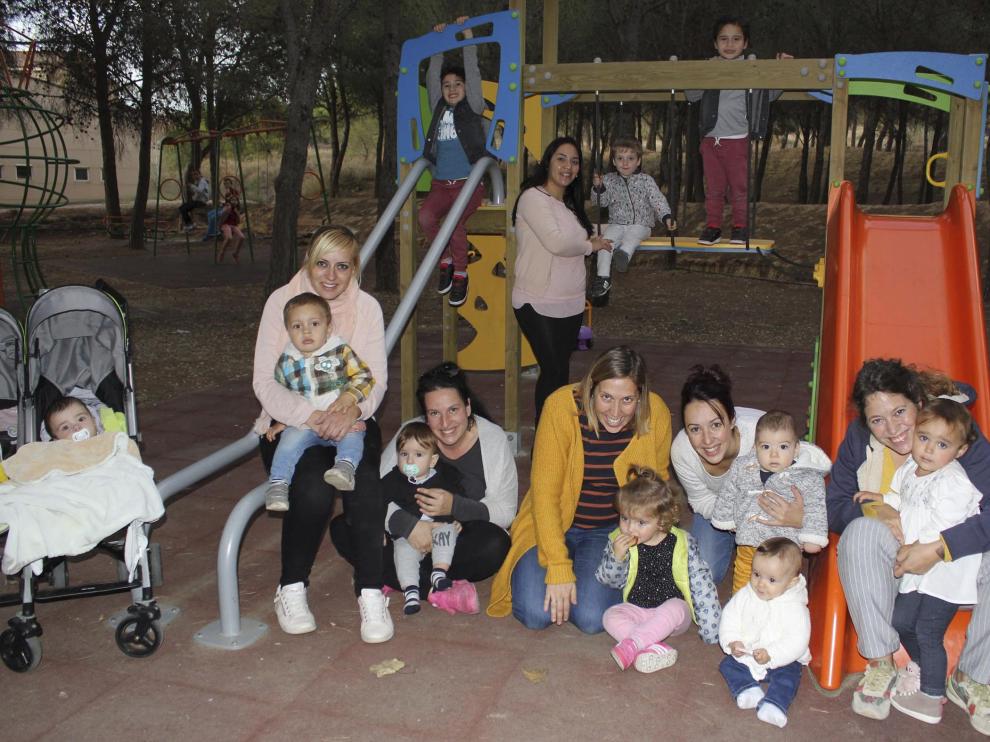 Niños y madres posan en el parque infantil de Sodeto, donde ha repuntado la natalidad.