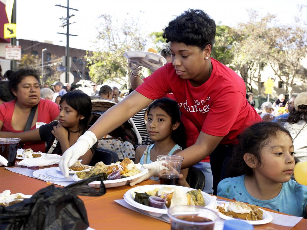 Una voluntaria entrega comida en Acción de Gracias a personas sin hogar