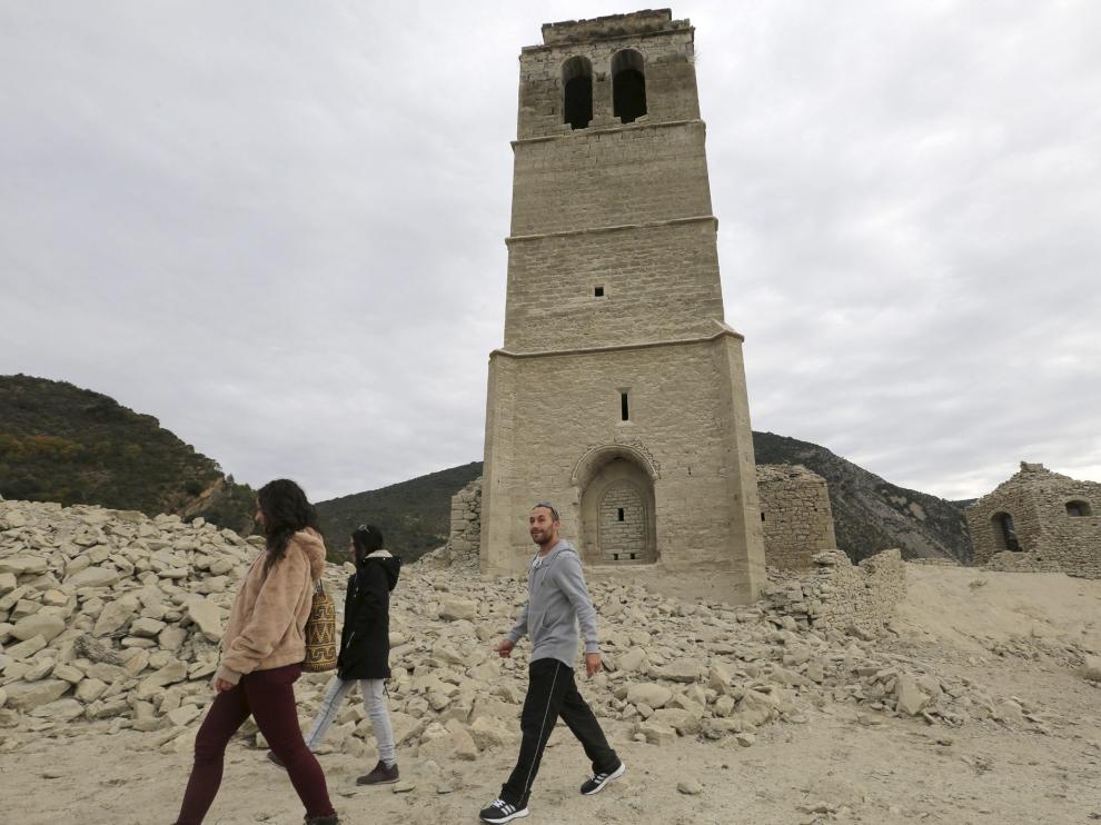 Periodistas y turistas, entre las ruinas de Mediano. No es extraño ver estos días a periodistas tomando imágenes de la tierra cuarteada en el vaso de Mediano y a turistas que se acercan hasta la iglesia del pueblo inundado en 1969. La imagen se ha podido ver otras veces en verano. Lo inusual es que esté así en otoño.