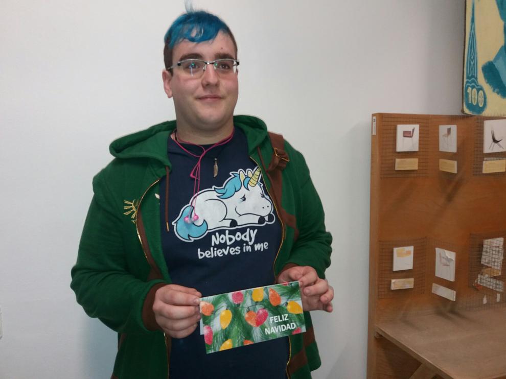 El ganador del concurso posa con la tarjeta navideña que ha diseñado.