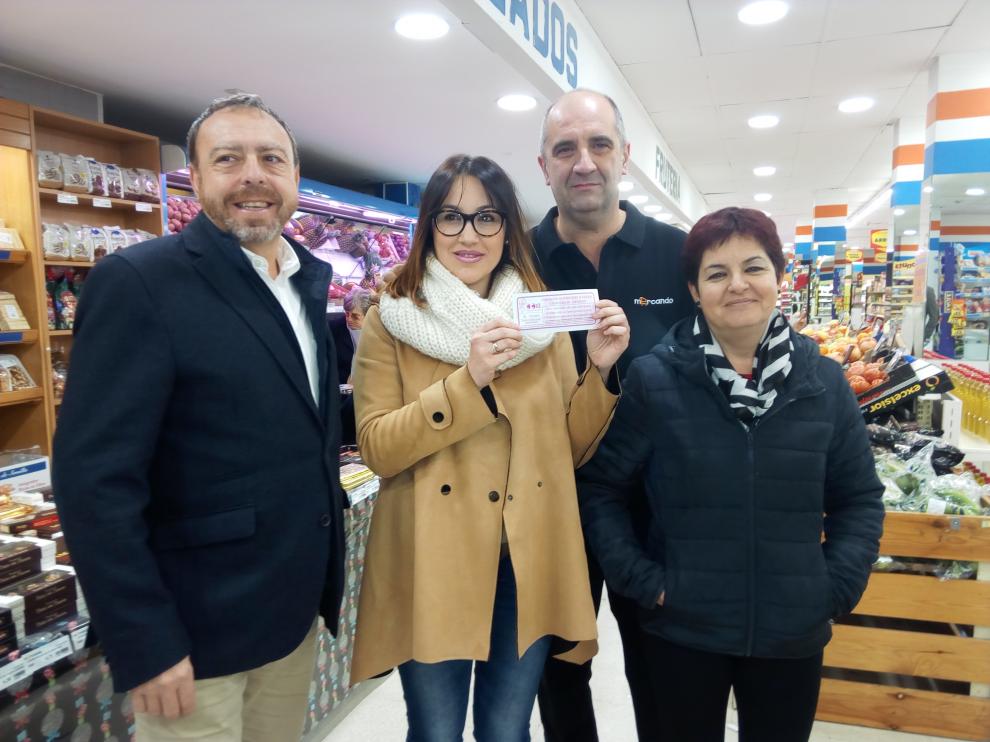 Responsables de la ACT y de la tienda que repartió el boleto ganador posan con la ganadora del premio, Mara Led.