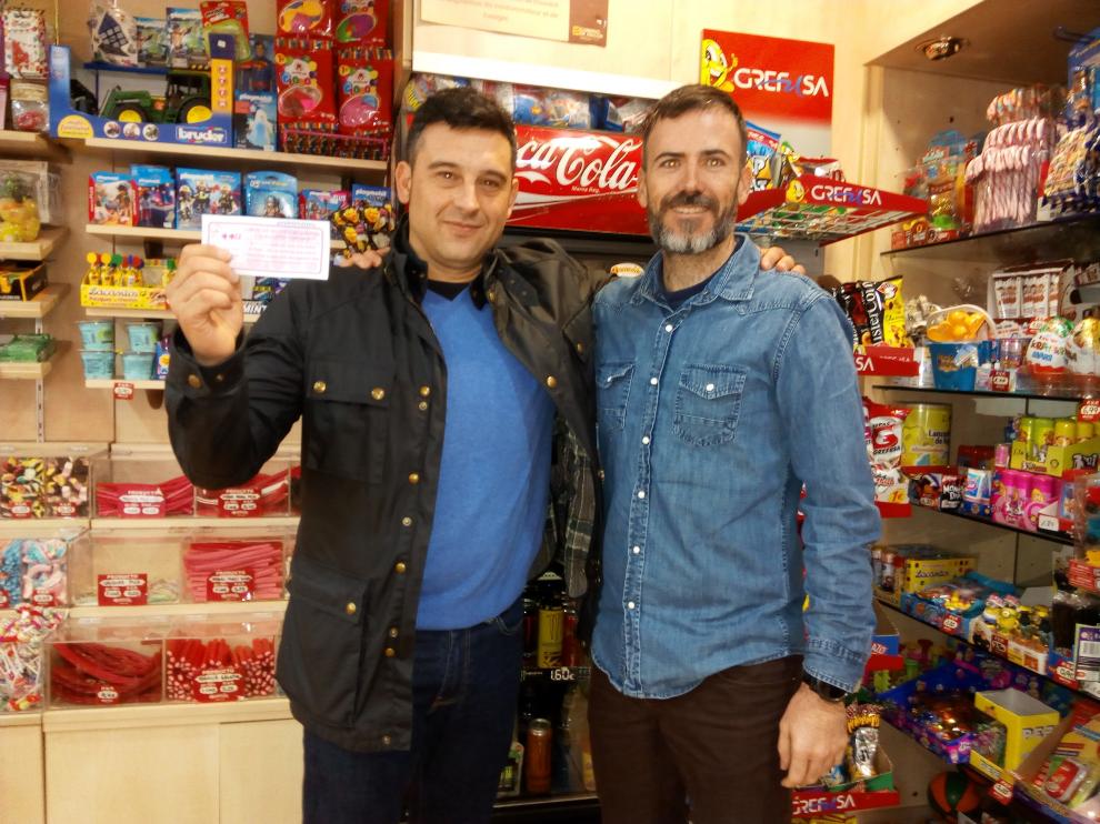 El ganador César González posa con el boleto y Sergio Orta, responsable del comercio que le repartió la papeleta de la suerte.