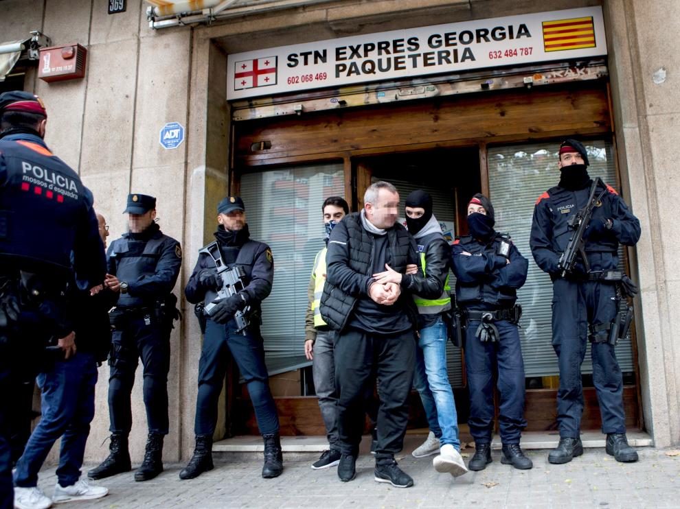 Miembros de la Policía Nacional y Mossos d'Esquadra custodian uno de los locales registrados