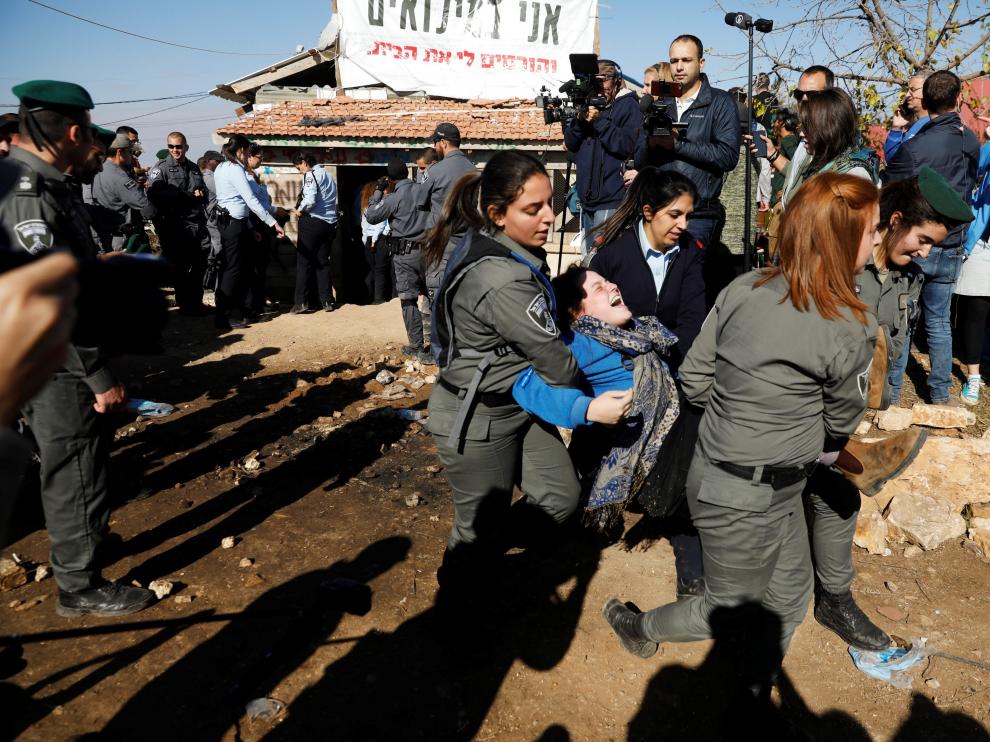 La policía israelí desaloja a una mujer de una de las estructuras de Netiv Haavot, la cual debe ser demolida antes de marzo de 2018