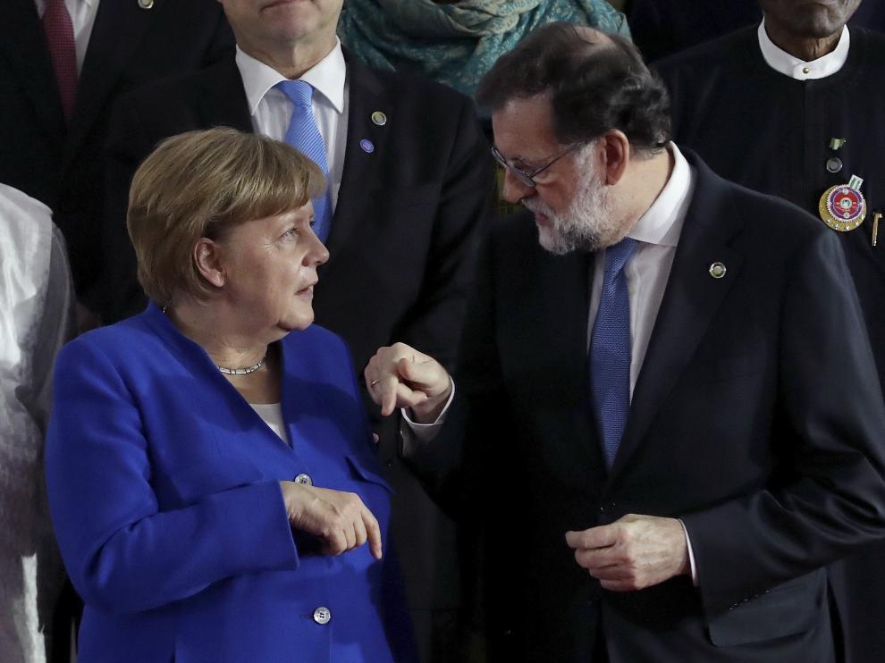 Mariano Rajoy conversando con la canciller Angela Merkel.
