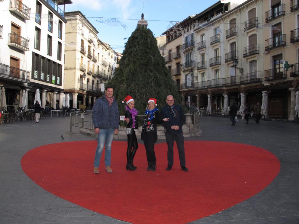 El concejal Javier Domingo, a la izquierda, posa junto al árbol de Navidad de la plaza del Torico.