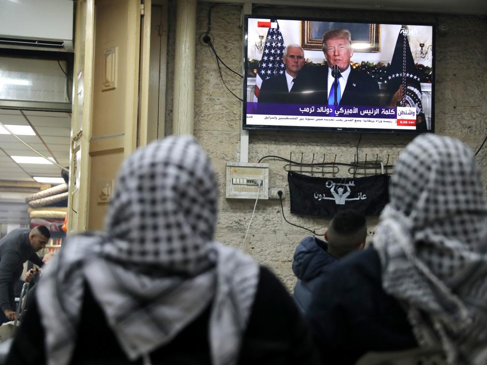 Dos palestinas ven por la televisión el anuncio de Trump.