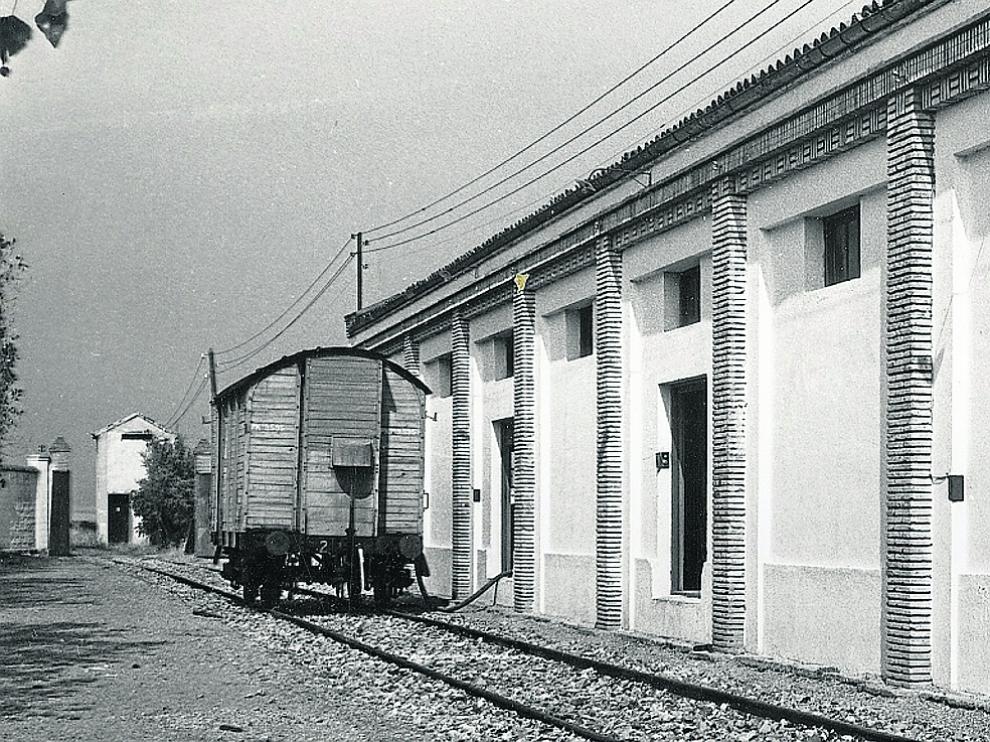 Un apartadero para el vino. Estas instalaciones, situadas en la propia estación de Cariñena, pertenecían a las ya desaparecidas Bodegas Balbino Lacosta. En la imagen antigua, captada en los años 50 del siglo pasado, se aprecia un vagón 'foudre' en plena labor de carga a través de una manguera.