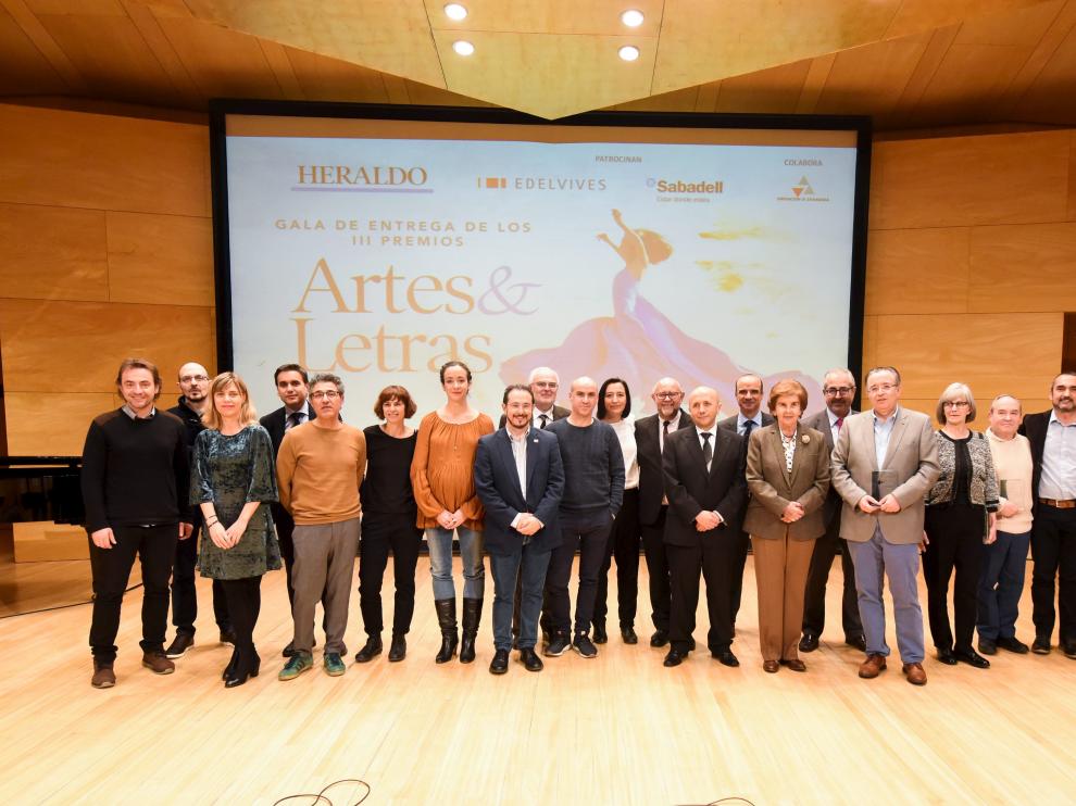 Los premiados por el suplemento 'Artes & Letras' y los encargados de entregar las distinciones, sobre el escenario de la sala Luis Galve al término de la gala.