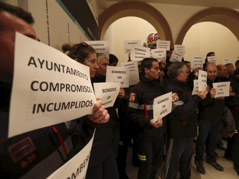 Bomberos y policías locales se concentraron en el vestíbulo del salón de plenos del Ayuntamiento de Huesca.