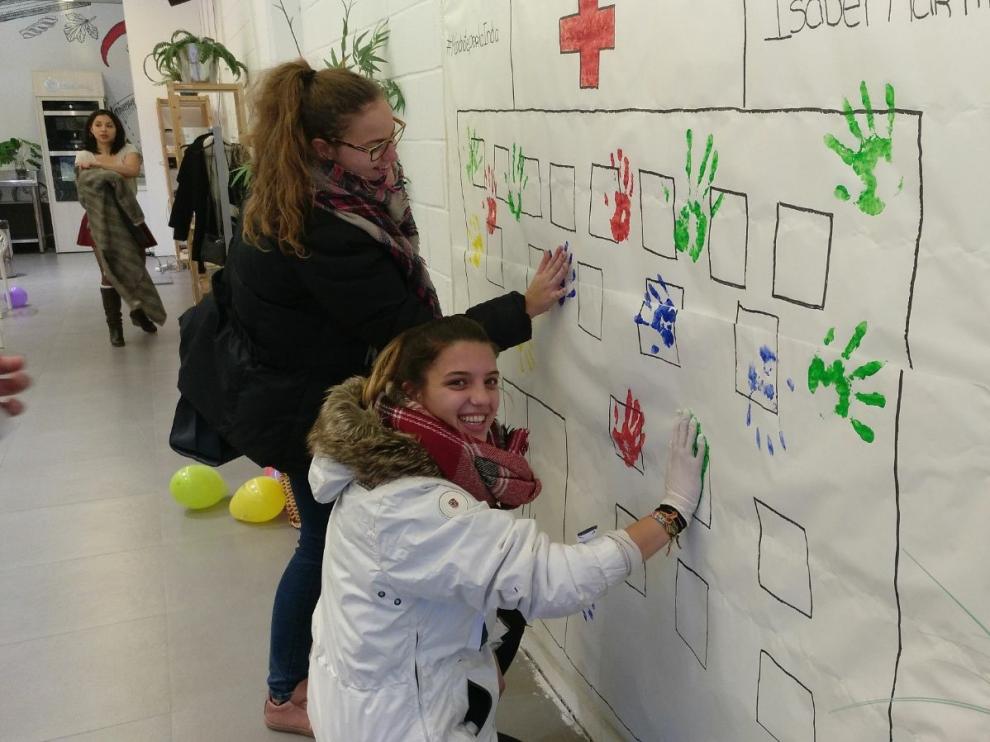 Un grupo de voluntarios estampando sus manos en el mural.
