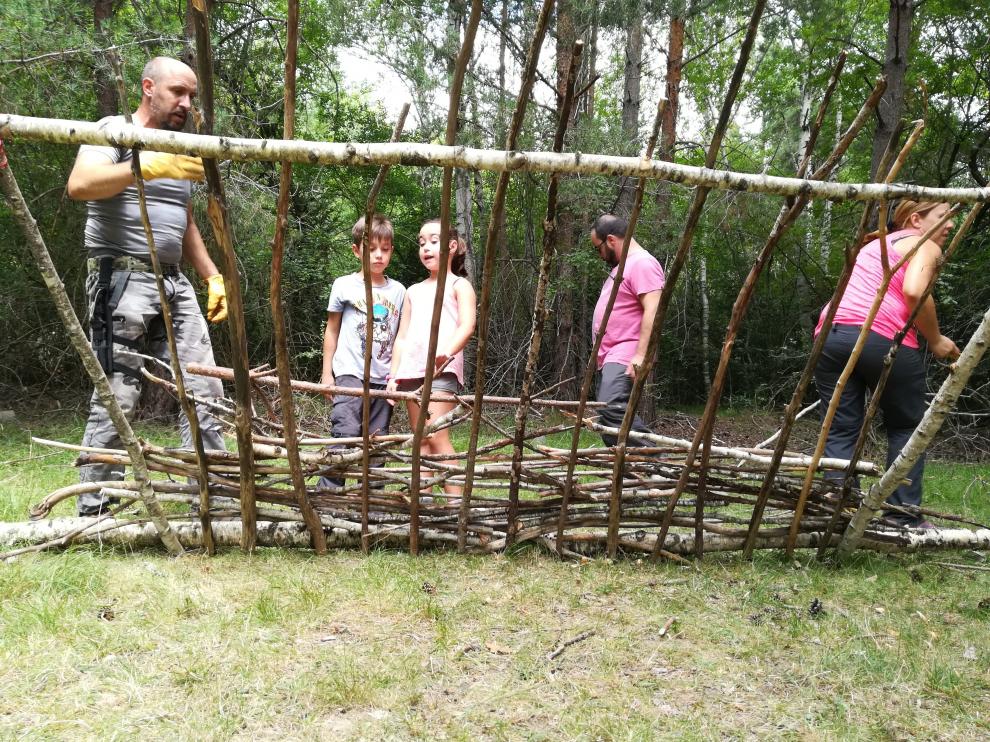 Construyendo un refugio con troncos y ramas, en la experiencia 'Superviviencia en familia', en Loarre.