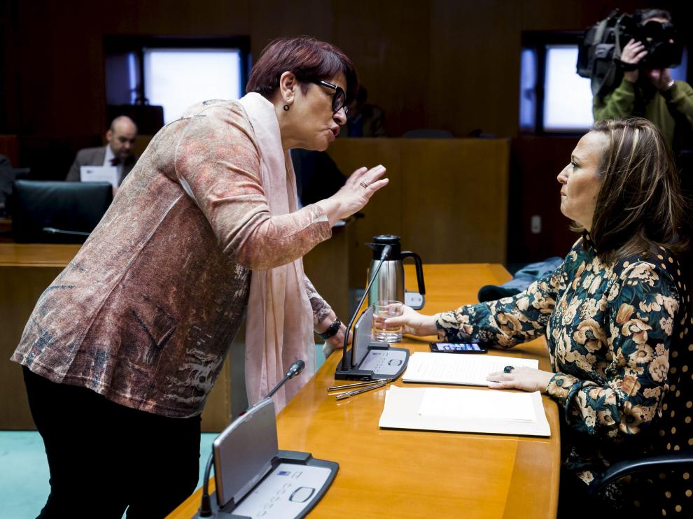 Margarita Périz, del PSOE, habla con la consejera de Educación, Mayte Pérez, antes de dar comienzo la comparecencia