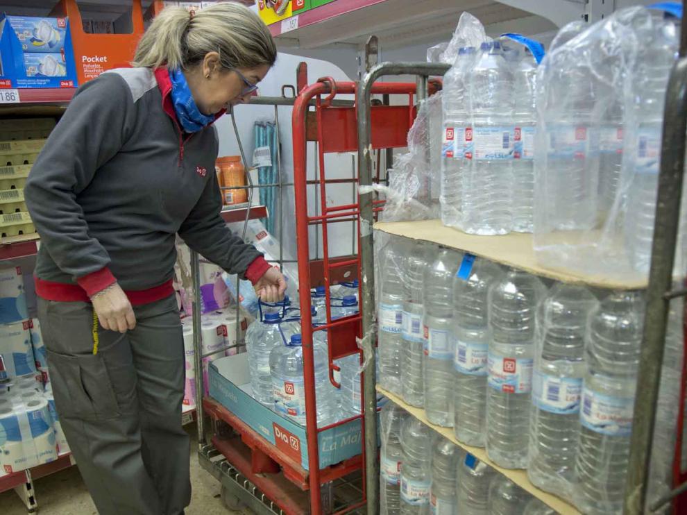 La empleada de un supermercado de Calatorao repone botellas y garrafas.