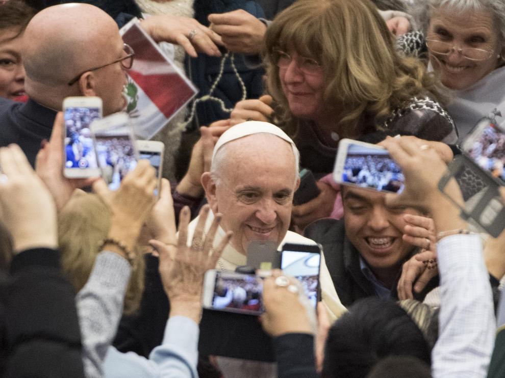 El papa Francisco saluda a las personas que asistieron a su audiencia semanal en el Vaticano.
