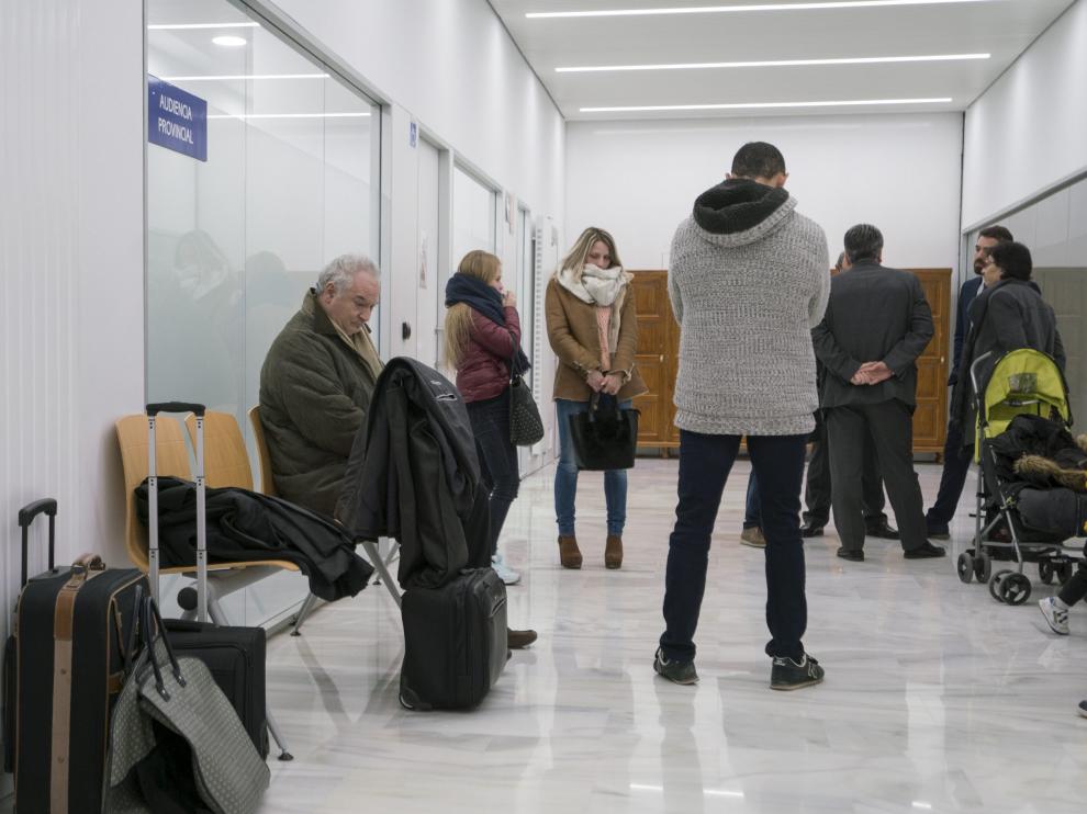 El pasillo de la Audiencia Provincial de Teruel, donde este lunes acusados y acompañantes aguardaban el inicio del juicio. En primer término, sentado, el principal acusado.
