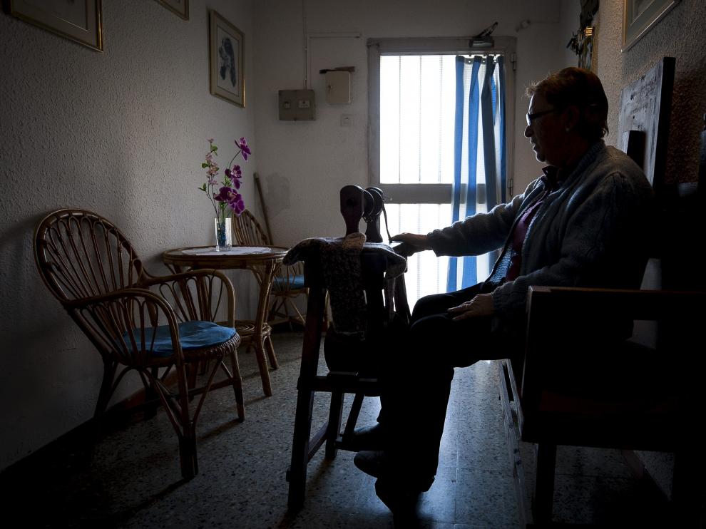 Emilia Puértolas se aplica con la máquina de hilar en el recibidor de su vivienda.