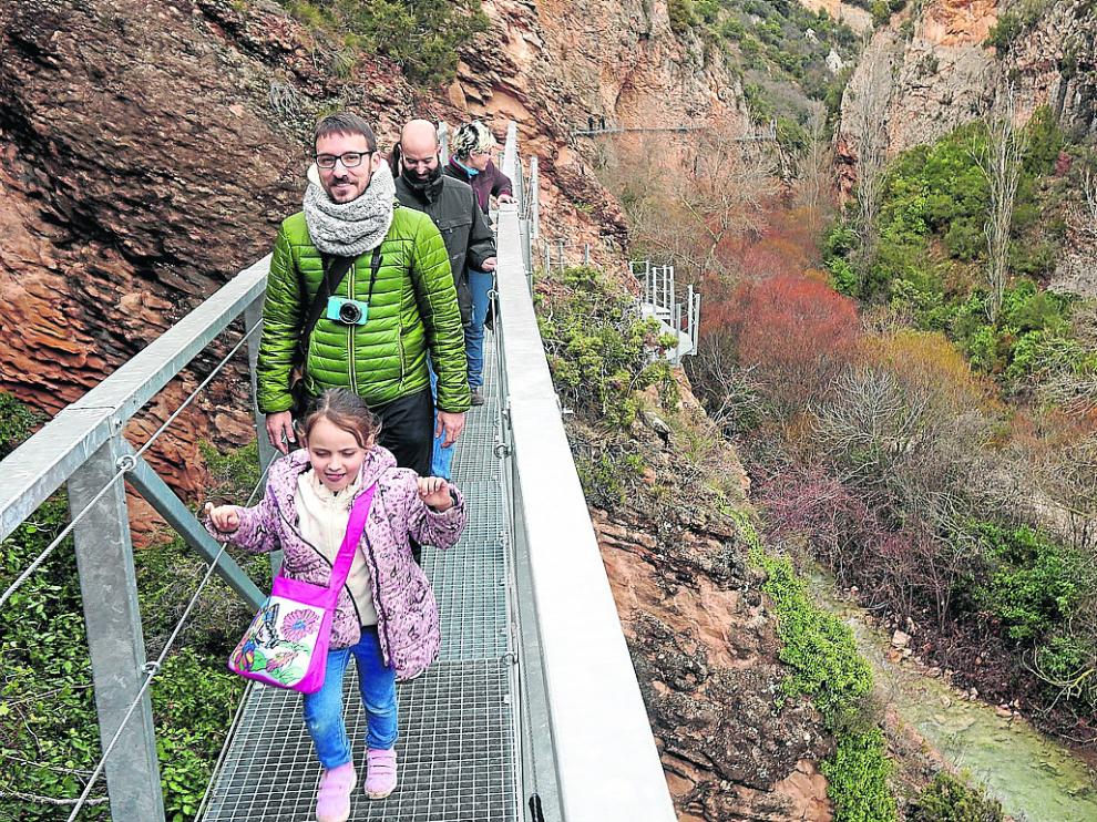 Nacho Azanza y su familia cruzando ayer el tramo reabierto de las pasarelas del Vero.
