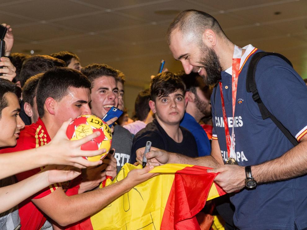 El jugador de la seleccion nacional de balonmano Joan Cañellas firma autógrafos a los aficionados a la llegada del combinado nacional al aeropuerto de Barajas, en Madrid. La selección de balonmano consiguió ayer su primer campeonato de Europa.