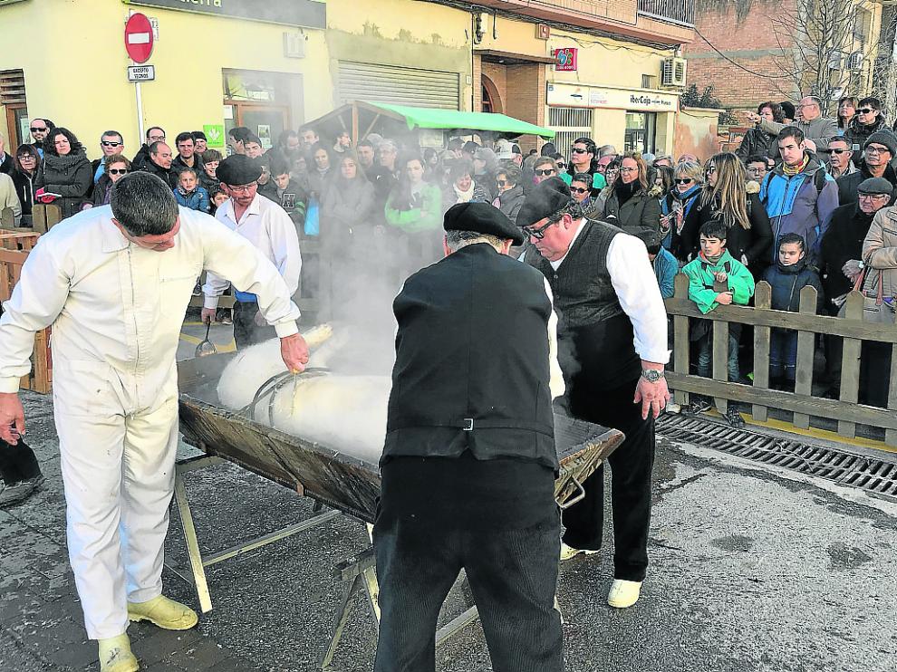 Los asistentes observan cómo se prepara el cerdo una vez que se ha realizado la matanza.