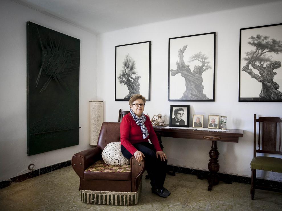 Manuela Fuertes, la hermana del desaparecido dibujante y pintor singrano; tras ella, tres obras del artista.