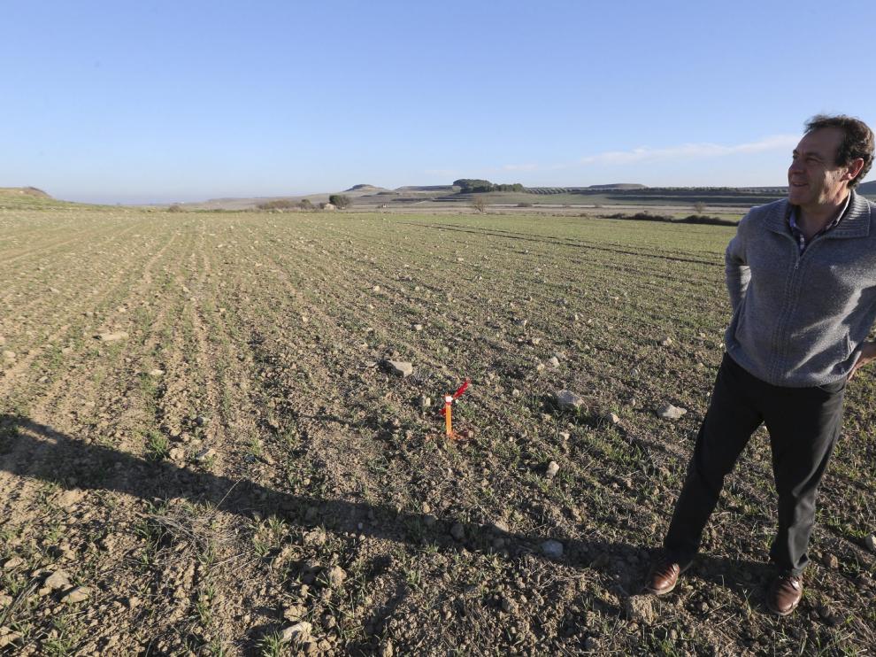 El alcalde de Almudévar, junto a las estacas colocadas en el emplazamiento de una de las presas.