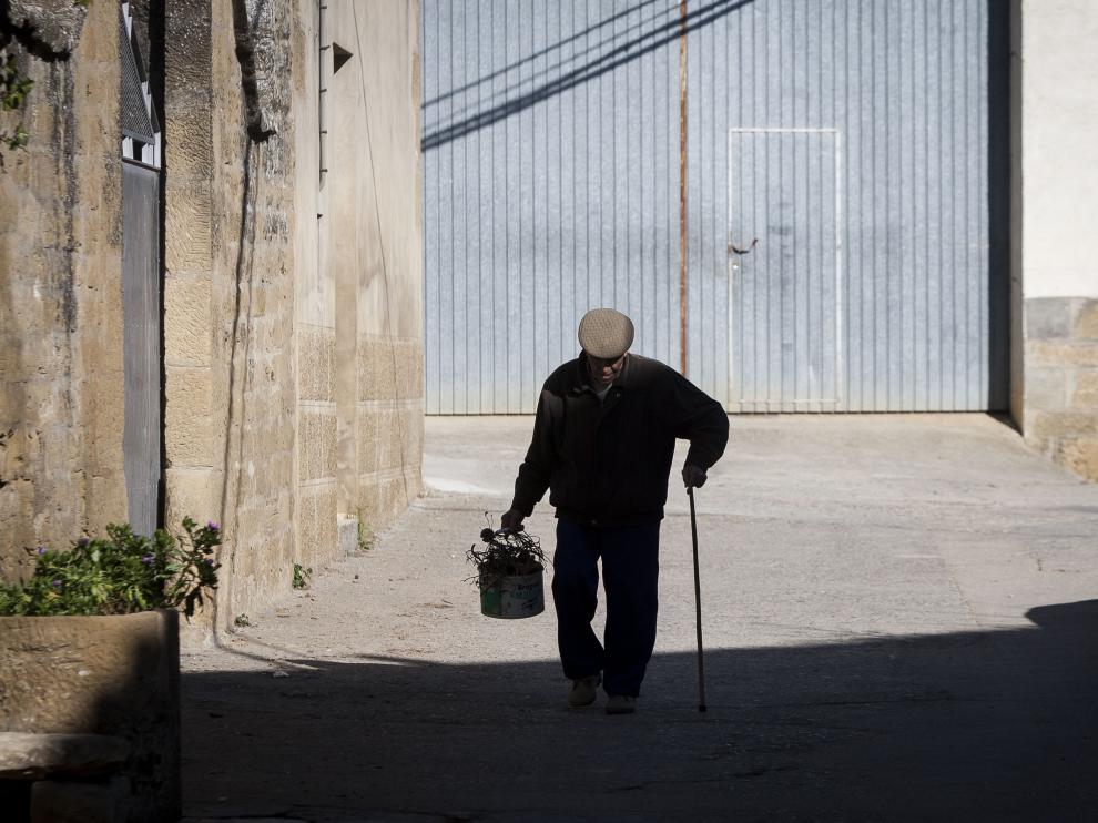 Un vecino de Biscarrués pasea al mediodía por el centro del pueblo.