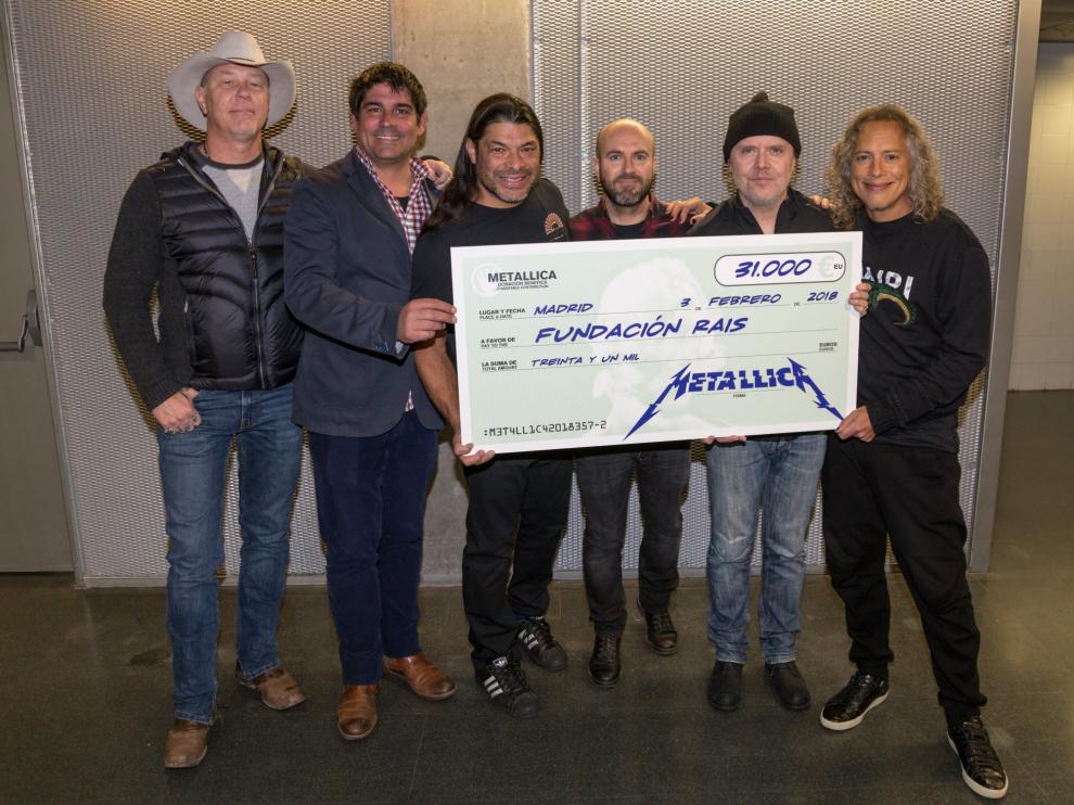Los integrantes de Metallica posando con el cheque de la donación en Madrid.