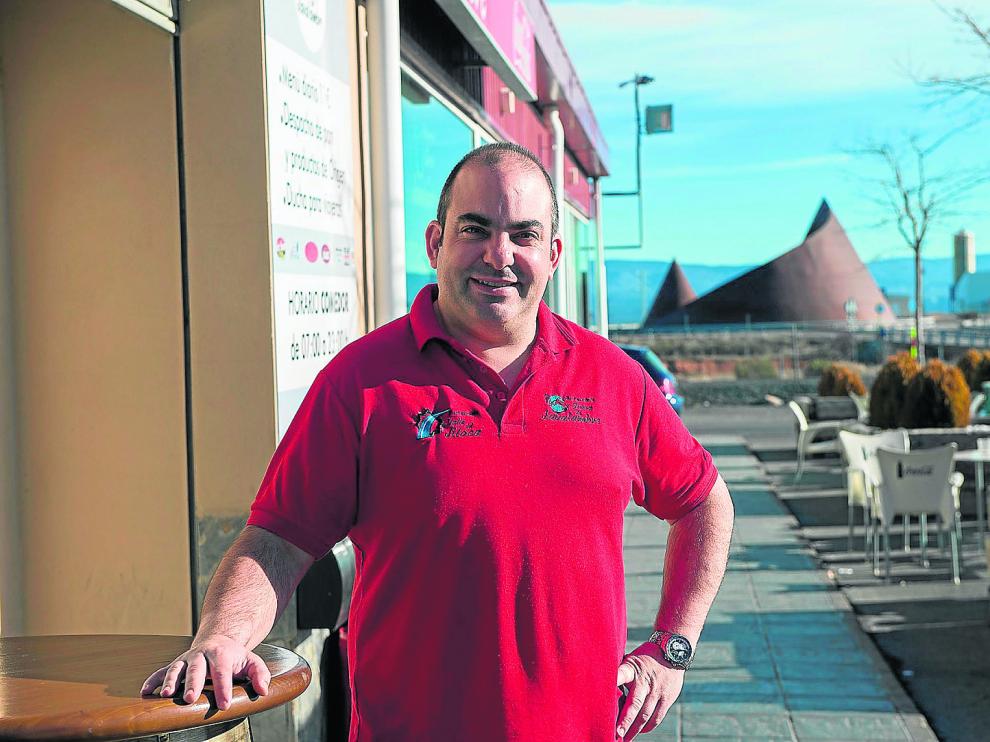 Goyo Rodríguez, en su restaurante situado a las puertas de La Puebla de Valverde y, al fondo, el monumento a la sierra de Javalambre.