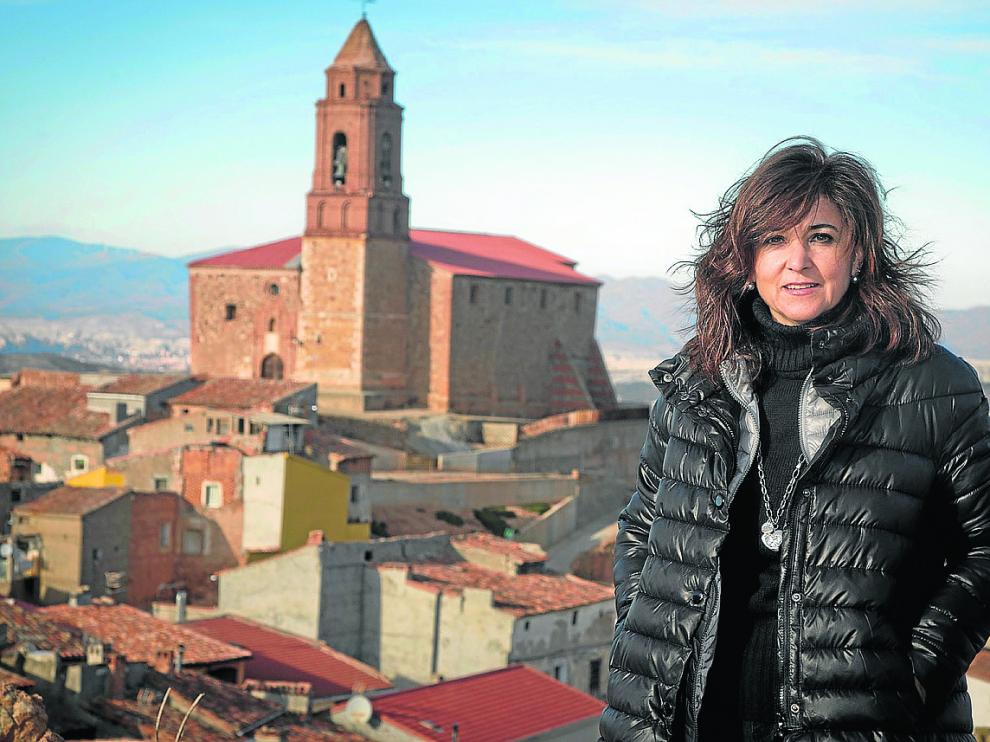 La alcaldesa posa delante de la iglesia de Olvés, cuya restauración continúa pendiente.