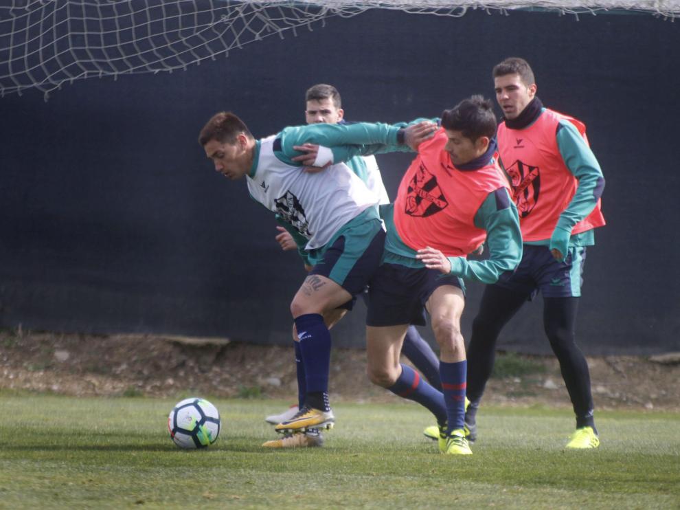 El delantero Chimy Ávila, que regresa hoy al once inicial del Huesca, pugna con Aguilera durante un entrenamiento.