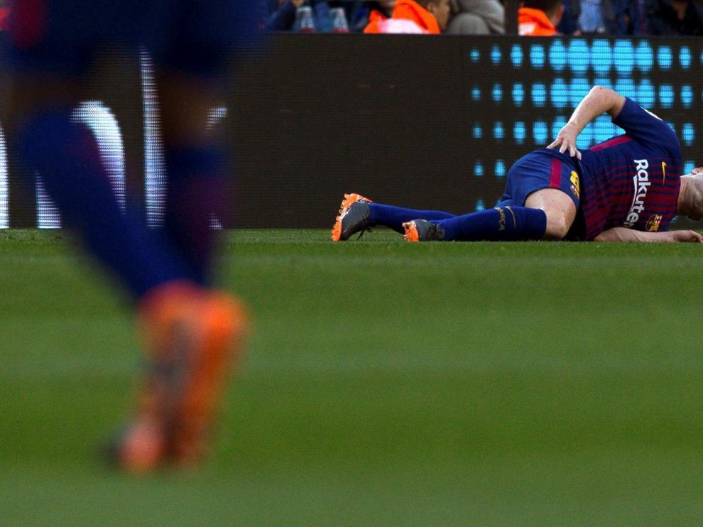 Iniesta en el suelo, lesionado durante el partido contra el Atlético de Madrid