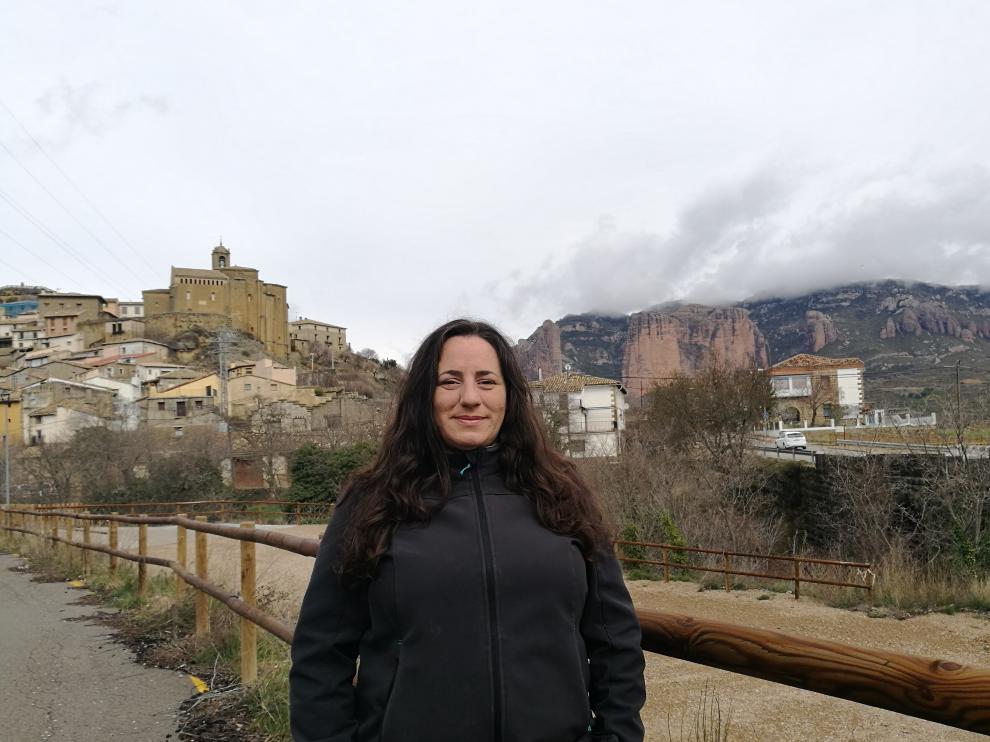 La alcaldesa de Murillo de Gállego posa ante el pueblo y los Mallos de Riglos.