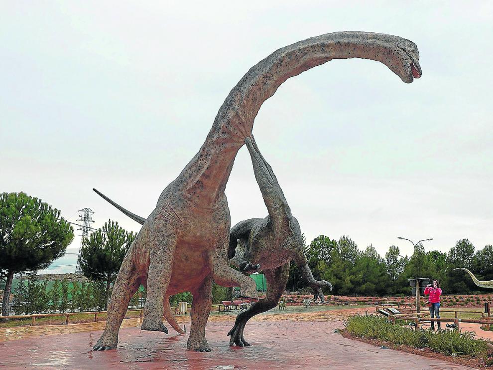 Un visitante de Dinópolis fotografía la reproducción de un Tastavinsaurus y un Baryonyx luchando entre sí.