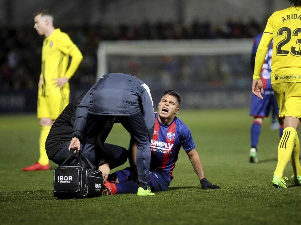 El delantero Cucho Hernández es atendido tras caer lesionado en el Huesca-Osasuna.