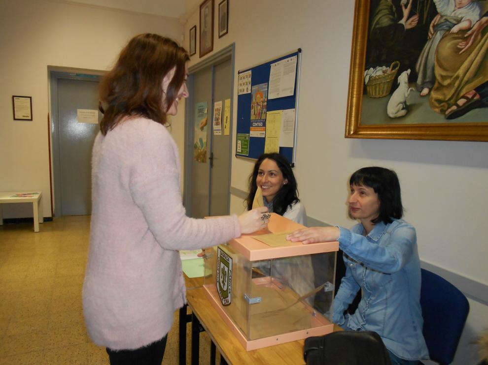 Una madre del colegio Sagrada Familia deposita su voto en la urna