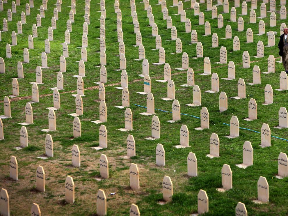 Un kurdo iraquí camina entre las lápidas de las victimas del ataque con gas letal de la ciudad de Halabja en 1988