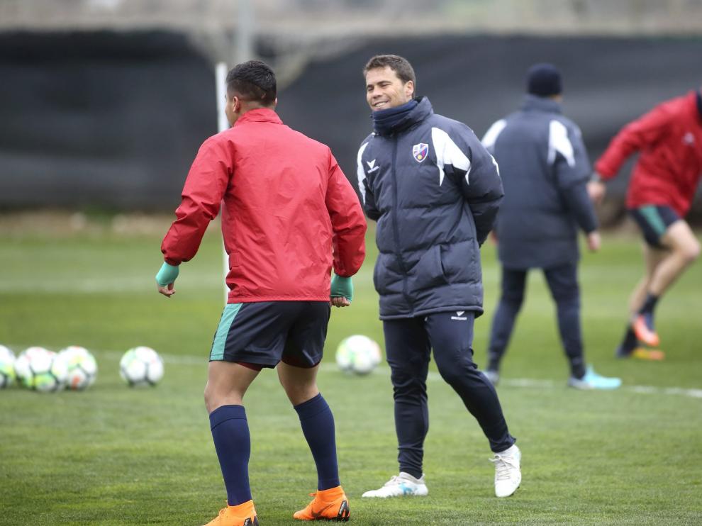 El técnico del Huesca, Joan Francesc Ferrer 'Rubi', sonriente mientras dialoga con Cucho Hernández en el entrenamiento de este miércoles en el Instituto Montearagón.