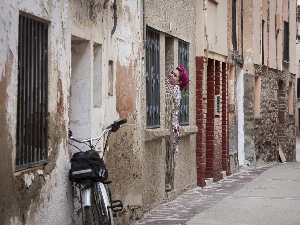 Una vecina se asoma a la calle desde el portal, en el centro de Tabuenca.