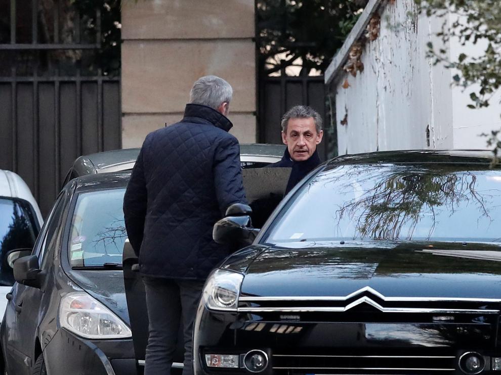 Sarkozy saliendo de su domicilio en París acompañado por su abogado para dirigirse al interrogatorio