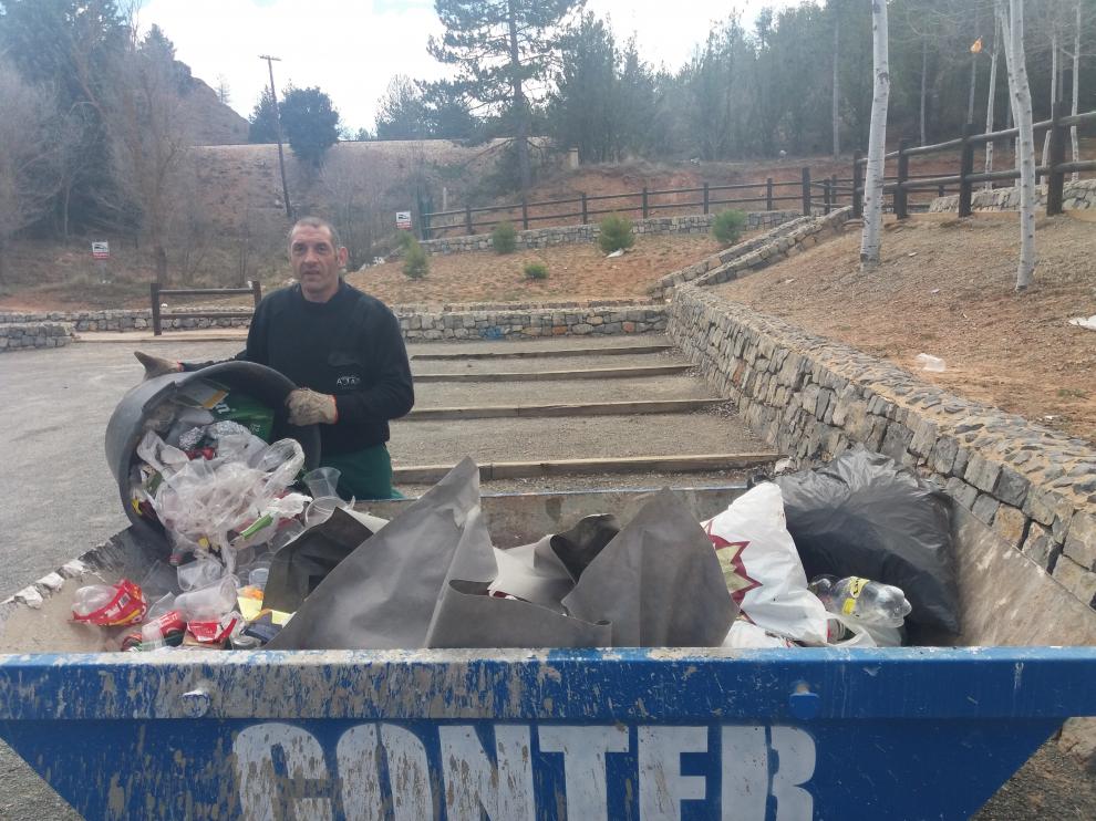 Un trabajador de Atadi recoge la basura desperdigada por Fuente Cerrada.