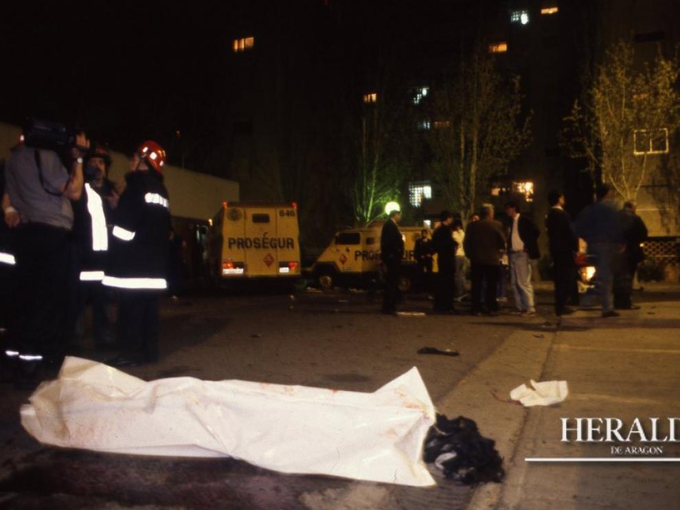 Uno de los cadáveres yace entre manchas de sangre en el lugar del atentado terrorista frente a la fachada de Galerías Primero ubicado en el barrio zaragozano de Monsalud, el 7 de abril de 1993.