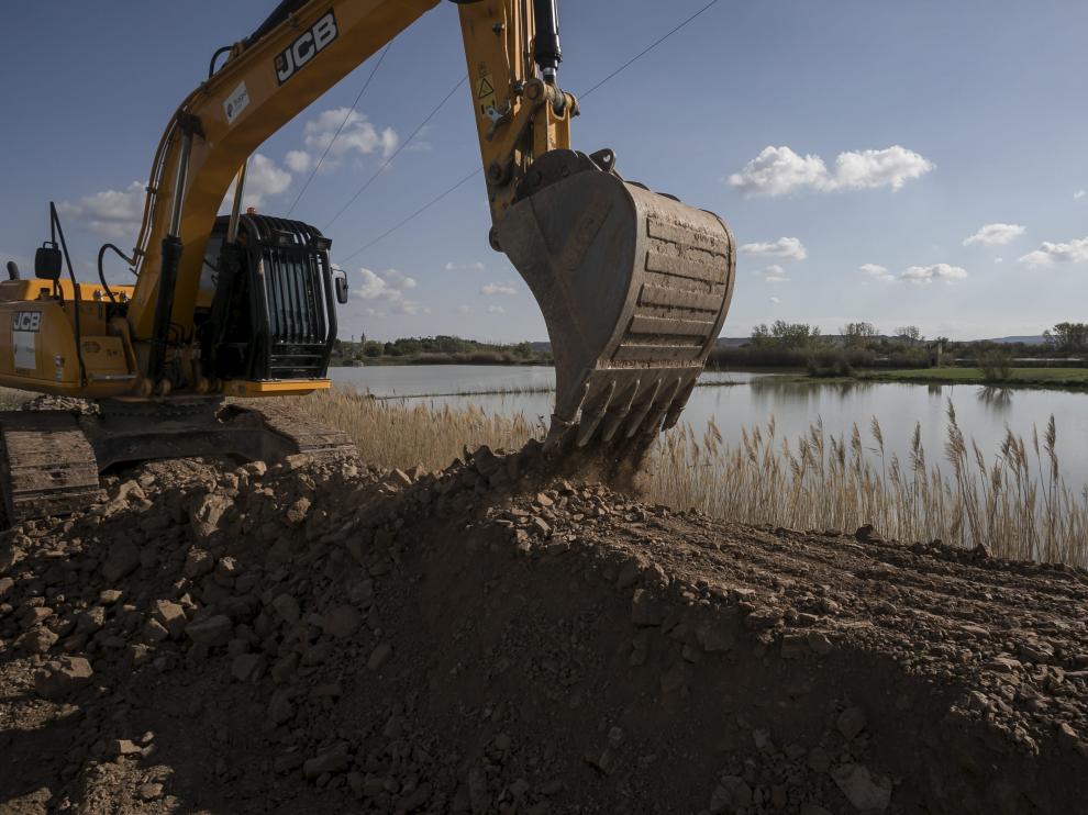 Operarios de Tragsa levantan una barrera en Pina de Ebro, el municipio que más preocupa