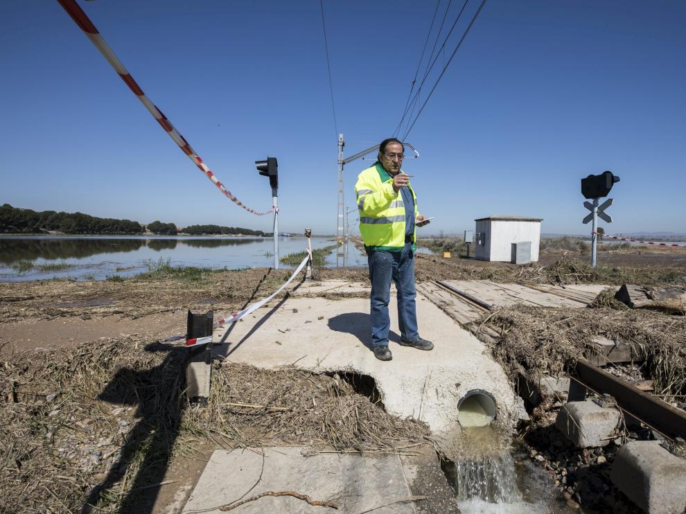 Un operario del ADIF, ayer, evaluando los daños que la avenida del Ebro ha causado en la línea ferroviaria Zaragoza-Reus.