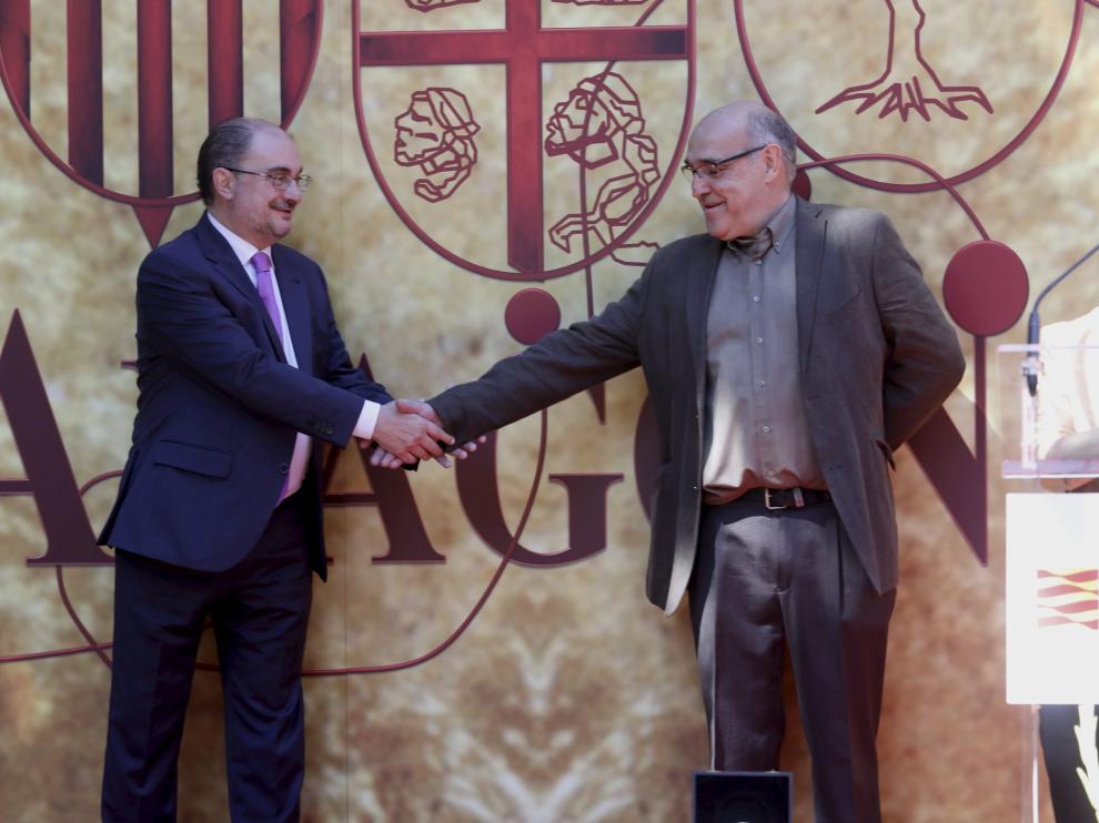 Javier Lambán da la mano a Paco Paricio mientras Pilar Amorós agradece la medalla concedida.