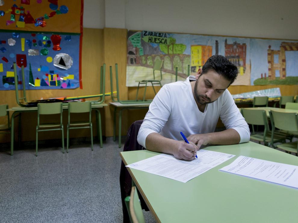 Juan Clavería rellena la solicitud de plaza escolar en el aula de psicomotricidad del colegio Parque Goya.