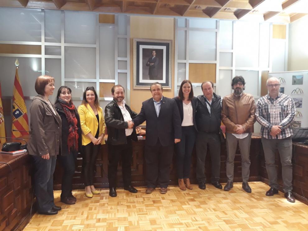 A la izquierda, el nuevo presidente junto a su nueva junta. Este se da la mano con el expresidente Francisco Abués, acompañado de Susana Lacasa, concejal del Ayuntamiento de Jaca, Santiago Tomás, el síndico de este año, y otros dos miembros de la junta saliente de Arbués